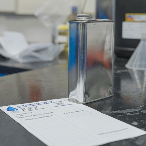 A metal container on top of a Chem Group Analysis report.